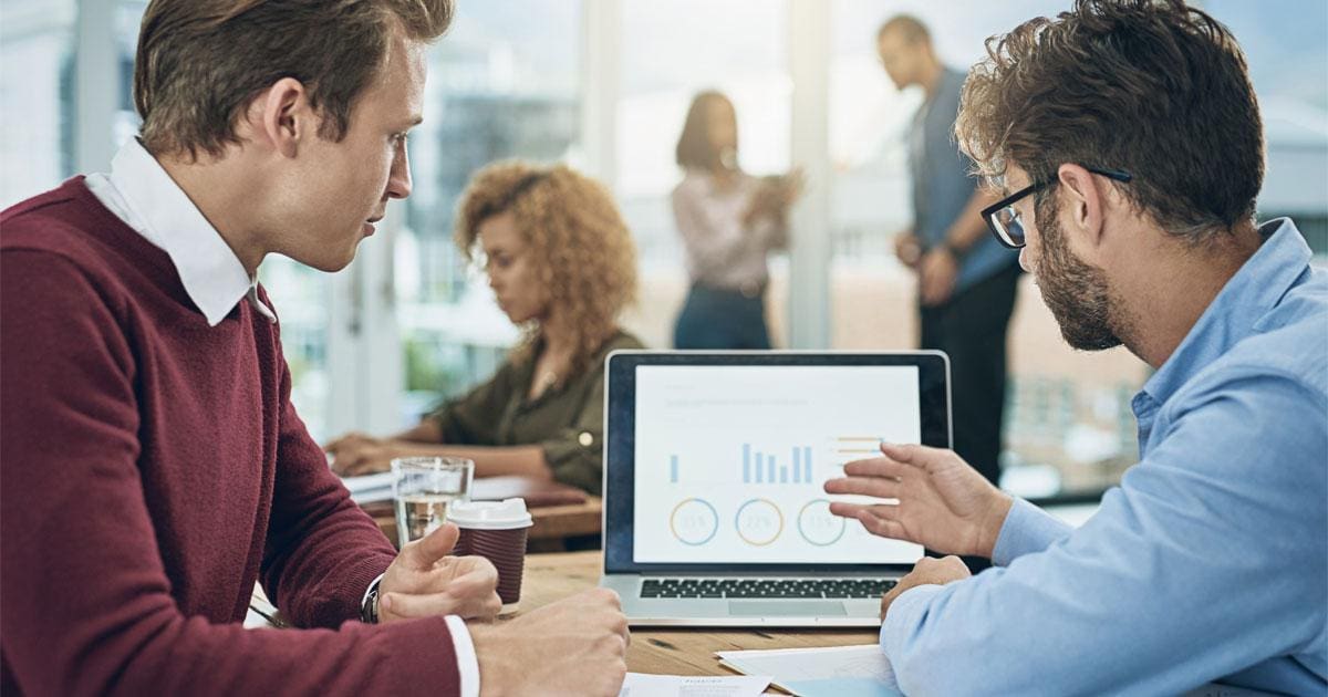 A team of professionals discussing employee turnover data on a computer screen